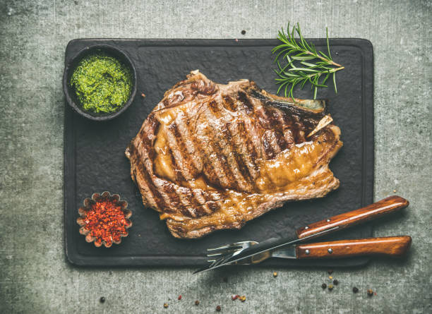 istock Grilled hot rib-eye beef steak on bone with chimichurri sauce 869977744