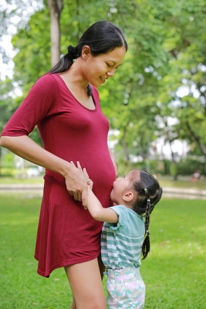 istock Happy Sister Hugging Pregnant Mother. 869981092