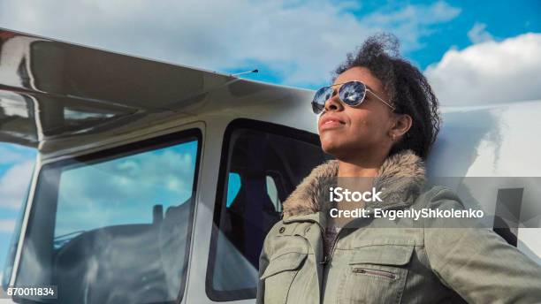 Attractive Woman Pilot Resting Against Her Plane Stock Photo - Download Image Now - Pilot, Females, African Ethnicity