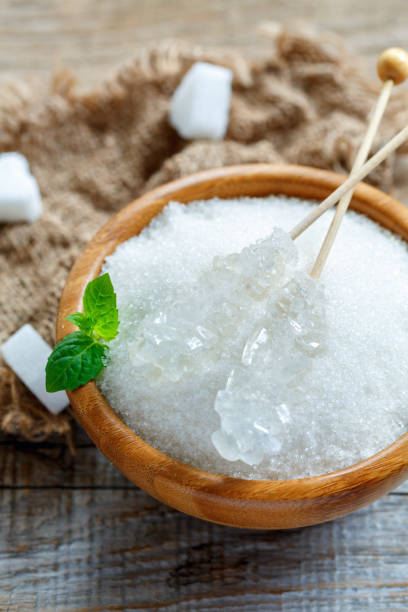 istock Sticks with crystal white sugar in a wooden bowl. 870012712