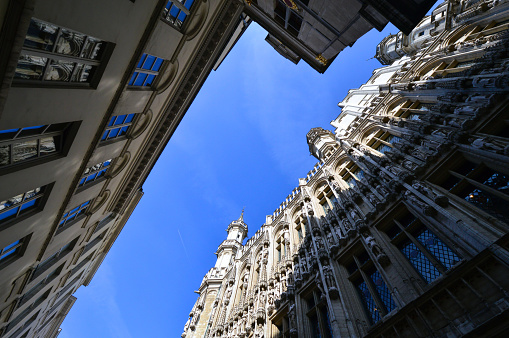Low angle view of the Town Hall of the City of Brussels, a building of gothic architectural style from the middle ages located at the Grand Place in Brussels, Belgium