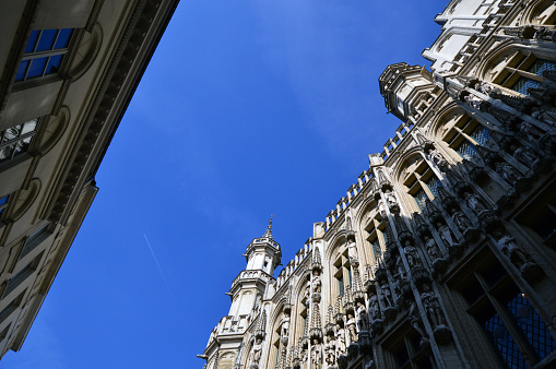 Low angle view of the Town Hall of the City of Brussels, a building of gothic architectural style from the middle ages located at the Grand Place in Brussels, Belgium