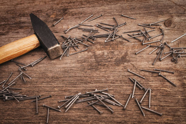 istock metal Hammer and nails on wooden board 870018944