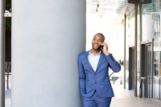 istock young african businessman talking on cell phone while in the city 870026488