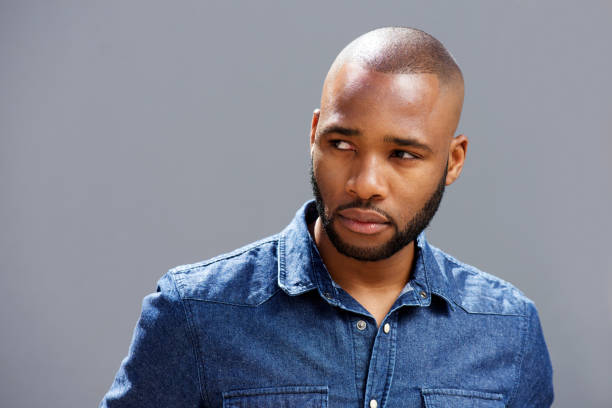 istock Close up handsome black guy looking away against gray wall 870026744