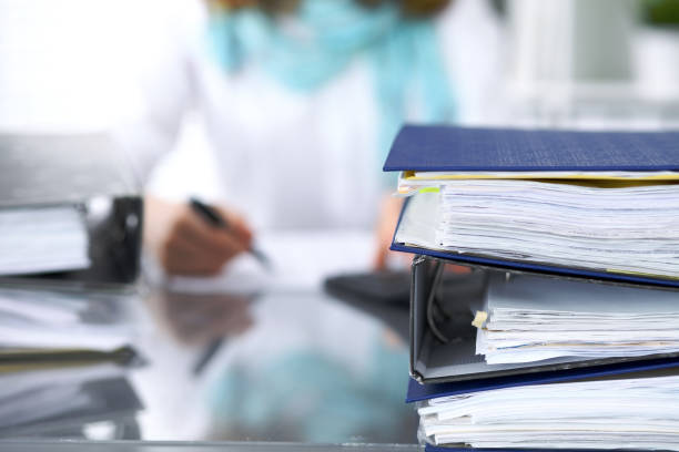 reliures avec papiers attendent d’être traitées avec la femme d’affaires ou secrétaire en flou. inspecteur de revenue service interne contrôle document financier - businesswoman form finance women photos et images de collection