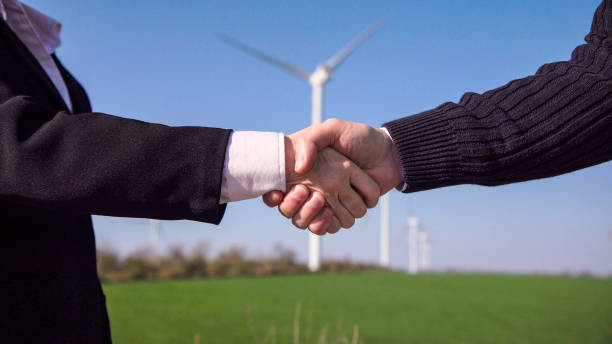 istock Business handshake against wind turbines 870029942