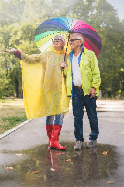 istock Senior couple with a rainbow umbrella 870030264