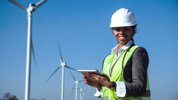 istock Woman with hard hat against wind turbine 870031246