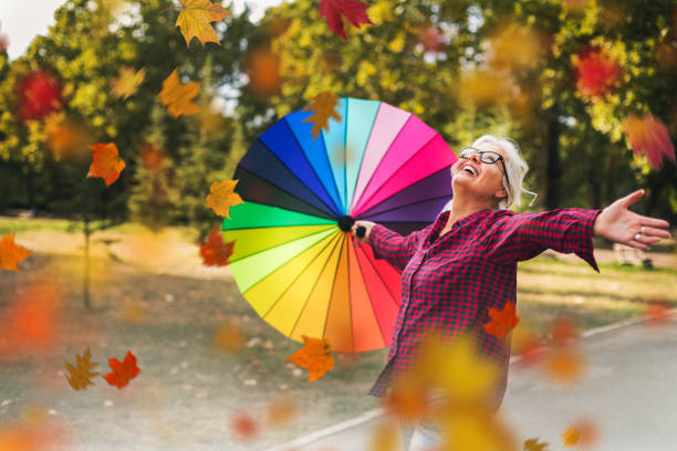 felice donna matura all'aperto in autunno - autumn women leaf scarf foto e immagini stock