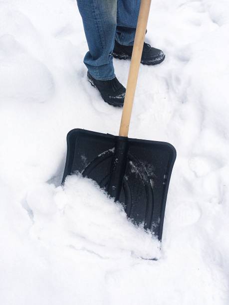 istock Man with snow shovel cleaning snow 870041844