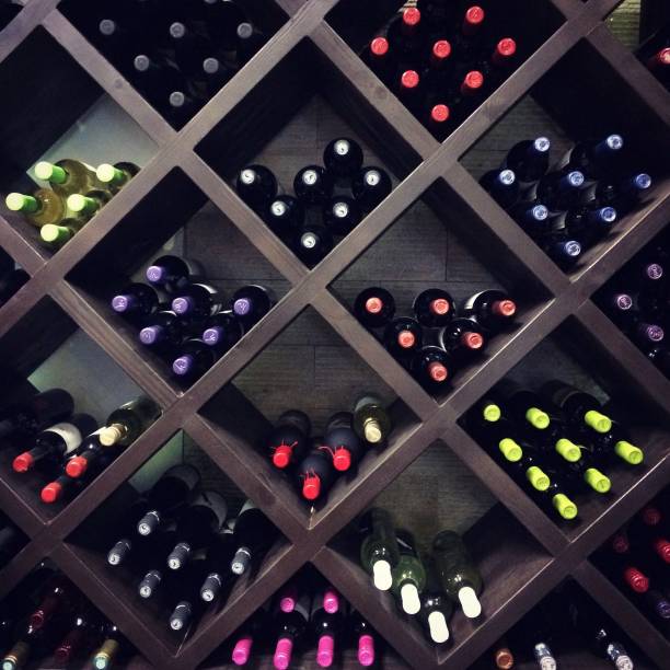 bouteilles de vin sur les tablettes - cellar photos et images de collection