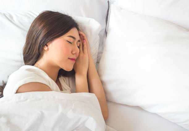 piękna azjatycka kobieta śpiąca na białym łóżku z szczęśliwym uczuciem - quilt back zdjęcia i obrazy z banku zdjęć