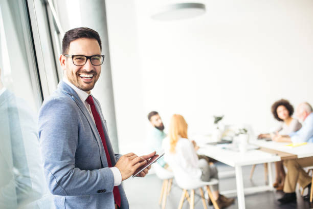 istock Handsome businessman working in modern office on a digital tablet 870055948