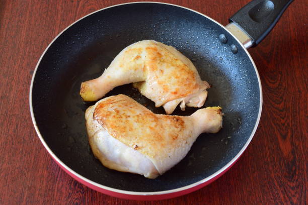 istock Chicken thighs fried in a frying pan on olive oil 870056246