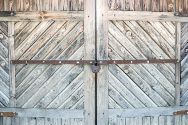 istock Old wooden door with the padlock. Close up 870057716
