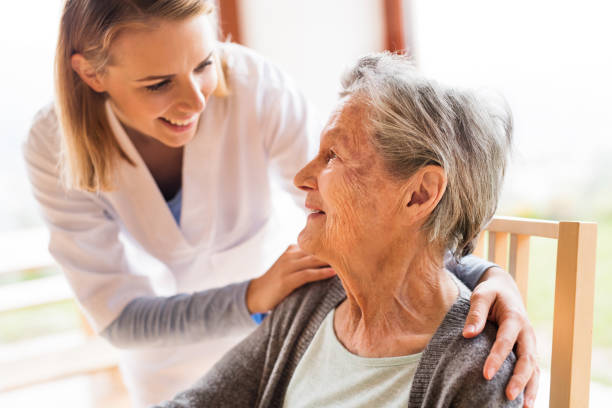 health visitor and a senior woman during home visit. - senior adult old nursing home people imagens e fotografias de stock