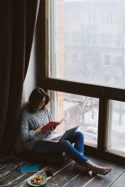 istock Young woman using laptop in a loft apartment 870060220