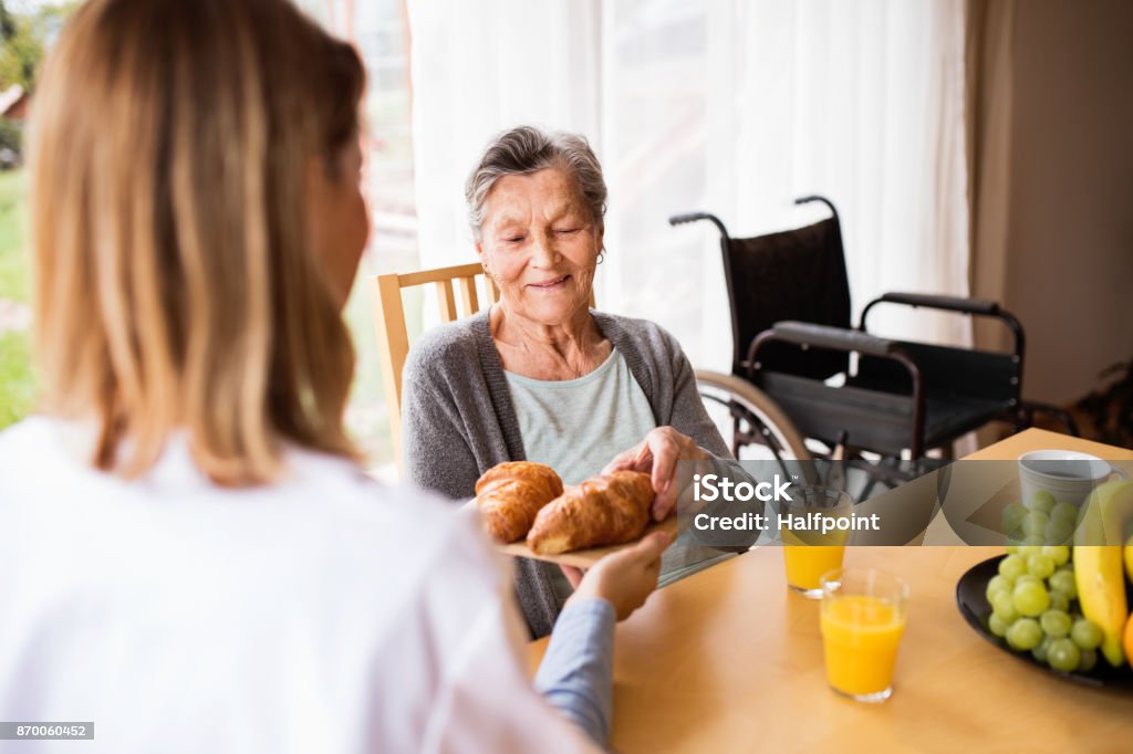 Sanitario y una mujer senior durante la visita a domicilio. - Foto de stock de Tercera edad libre de derechos