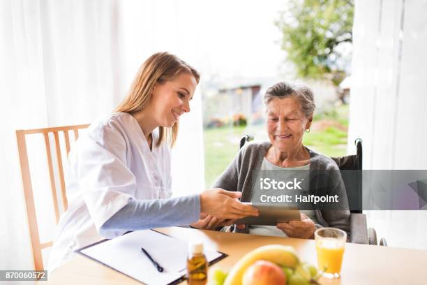 Health Visitor And A Senior Woman With Tablet Stock Photo - Download Image Now - Home Caregiver, Digital Tablet, Senior Adult