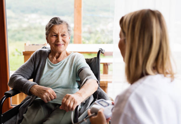 sanitario y una mujer senior durante la visita a domicilio. - resting fotografías e imágenes de stock