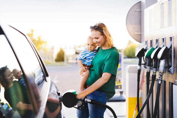 giovane madre con bambino al distributore di benzina. - pieno foto e immagini stock