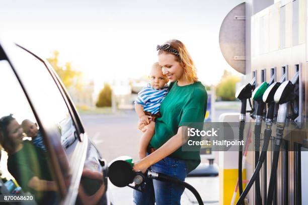 Young Mother With Baby Boy At The Petrol Station Stock Photo - Download Image Now - Refueling, Car, Gasoline