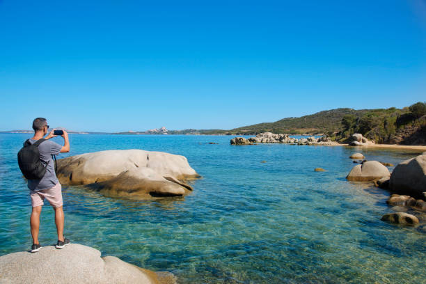 istock young man taking a picture in Sardinia, Italy 870071648