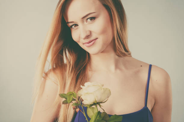 istock woman holding white rose 870072686