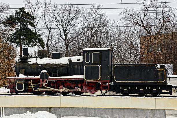 istock Old black locomotive under snow 870076572