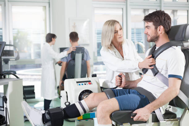 gym physiatric rehabilitation physicians with patients in a gym for physical rehabilitation dynamometer in the foreground and in the background cycle ergometer sports medicine photos stock pictures, royalty-free photos & images
