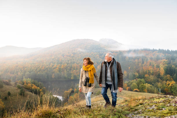 starsza para na spacerze w jesiennej przyrodzie. - hiking senior adult couple heterosexual couple zdjęcia i obrazy z banku zdjęć