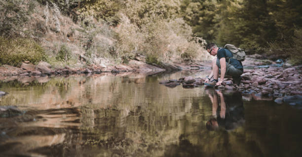istock Hiker taking a rest at mountain creek 870087874