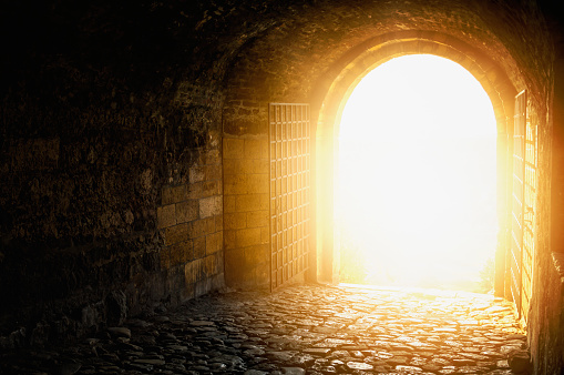 Door to Heaven. Arched passage open to heaven`s sky. Light at end of the tunnel. Hope metaphor.