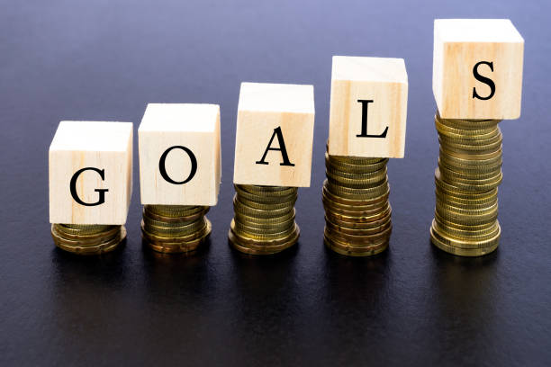 istock Goals Word on Wood Block on Top of Coins Stack 870111100