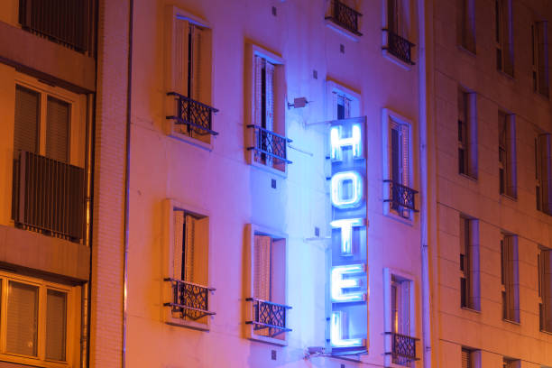 istock Paris building facade with illuminated neon hotel sign at night 870121990