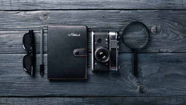 istock Office work space with camera, notebook, eyepieces, and pen. On a wooden surface. Top view. Free space for your text. 870137722