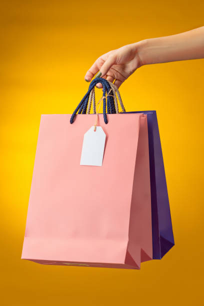 female hand holding bright shopping bags - baby beautiful part of selective focus imagens e fotografias de stock