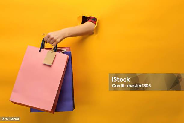 Female Hand Holding Bright Shopping Bags Stock Photo - Download Image Now - Retail, Bag, Shopping