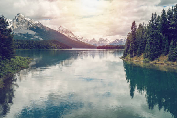 One man in the middle of nature, in a canoe on Maligne Lake, seen from Spirit Island, Jasper national park, Canada.