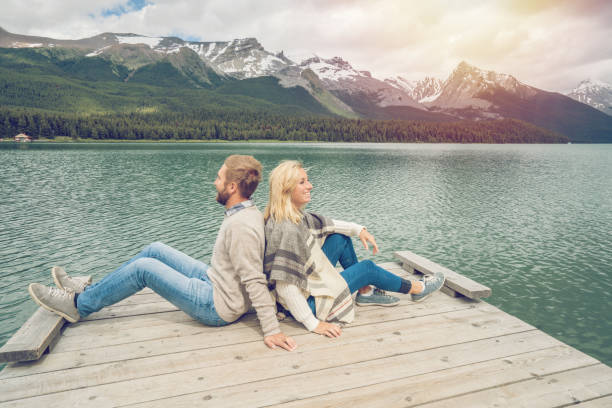 istock Young couple relaxing on lake pier in Canada 870147212