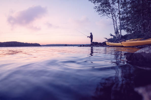 istock Fisher at a beautiful lake at low light 870149908
