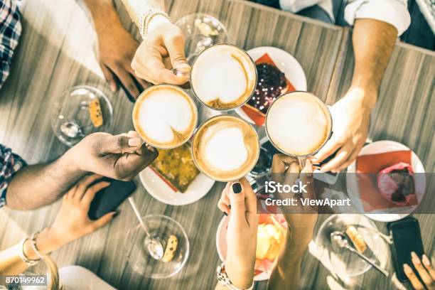Friends Group Drinking Cappuccino At Coffee Bar Restaurant People Hands Toasting At Fashion Cafeteria With Upper View Point Winter Drinks Concept With Men And Women At Cafe Warm Vintage Filter Stock Photo - Download Image Now