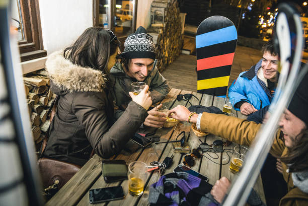 gelukkig vrienden bier drinken en eten van spaanders bij apres ski - vriendschap concept met vrolijke mensen plezier bij bar restaurant resort met sneeuw apparatuur - hoge iso-image met ondiepe scherptediepte - cafe snow stockfoto's en -beelden