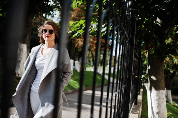 istock Girl in gray coat with sunglasses 870160666