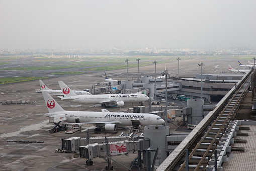 Tokyo, Japan - August 19, 2017: Airplanes at Tokyo International Airport (Haneda Airport) in Japan. It is located in Ota Ward, Tokyo, Japan. Tokyo International Airport is the busiest airport in Japan.