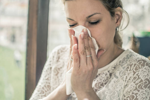 istock Blowing her nose in a napkin 870169386