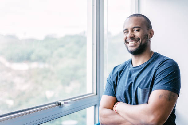 istock young smiling brazilian businessman at window in office 870180166