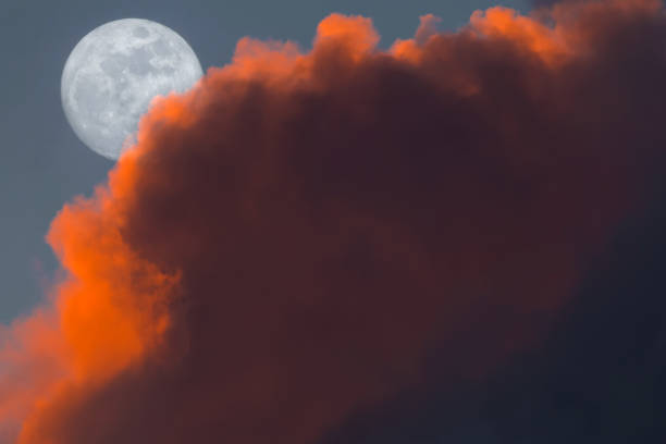 Photo of Full Snow Moon Rise peeking behind pink clouds during sunset