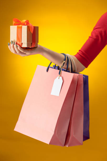 istock Female hand holding bright shopping bags 870181052
